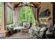 Inviting screened-in porch with comfortable seating, a fireplace, and wooded views at 4874 Kettle River Pt, Suwanee, GA 30024