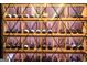 Close up of the well stocked, climate controlled wine cellar featuring custom wooden storage racks at 4874 Kettle River Pt, Suwanee, GA 30024