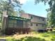 Home exterior with screened-in porch and deck surrounded by lush greenery at 3589 Burlingham Dr, Lithonia, GA 30038