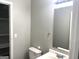 Cozy bathroom featuring a vanity sink, mirror, toilet, and closet with open shelving at 3589 Burlingham Dr, Lithonia, GA 30038