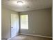 Neutral bedroom with carpet, a window with blinds, a white door, and a textured ceiling at 3589 Burlingham Dr, Lithonia, GA 30038