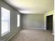 Bright living room with neutral walls, carpet, and large windows, offering a versatile space at 3589 Burlingham Dr, Lithonia, GA 30038