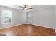 Bedroom featuring two windows for natural light, ceiling fan, neutral paint color, and laminate floors at 320 Cloverwood Drive, Fayetteville, GA 30215