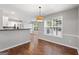 Bright dining area featuring hardwood floors, natural light from a large window, and modern light fixture at 320 Cloverwood Drive, Fayetteville, GA 30215