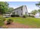 Exterior home view with a deck, green lawn, flower beds, and mature trees at 320 Cloverwood Drive, Fayetteville, GA 30215