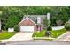 Lovely front exterior showcasing a well-kept lawn, attached garage, and brick facade at 320 Cloverwood Drive, Fayetteville, GA 30215