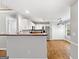 Open-concept kitchen features stainless steel appliances, white cabinets, laminate countertops, and wood look floors at 320 Cloverwood Drive, Fayetteville, GA 30215