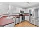 Bright kitchen features stainless steel appliances, white cabinets, laminate countertops, and wood look floors at 320 Cloverwood Drive, Fayetteville, GA 30215