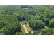 Aerial shot of a one-story home with a long driveway surrounded by lush green trees under a partly cloudy sky at 315 Antioch Road, Mcdonough, GA 30252