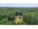 An attractive one-story home nestled among lush trees offering privacy and a long driveway under a partly cloudy sky at 315 Antioch Road, Mcdonough, GA 30252