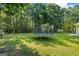 Large backyard featuring a trampoline and surrounding green lawn, perfect for outdoor activities at 315 Antioch Road, Mcdonough, GA 30252