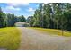 Residential exterior featuring a front lawn, long driveway, and mature trees at 315 Antioch Road, Mcdonough, GA 30252