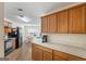 A cozy kitchen featuring wood cabinets, laminate counters and flooring and black appliances at 315 Antioch Road, Mcdonough, GA 30252