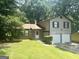 Two-story home featuring a two-car garage, brick accents, and lush green lawn at 4263 Southvale Dr, Decatur, GA 30034