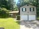 Two-story home featuring a two-car garage, brick accents, and lush green lawn at 4263 Southvale Dr, Decatur, GA 30034