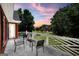 View of the decorative white railing and furniture on the balcony of the home with a sunrise in the background at 100 Castlebrook Chase, Tyrone, GA 30290