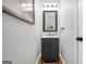 Powder room features a black vanity with white countertop and framed mirror at 100 Castlebrook Chase, Tyrone, GA 30290