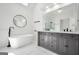 Modern bathroom with free-standing tub, frameless shower, double vanity and sleek fixtures at 100 Castlebrook Chase, Tyrone, GA 30290