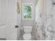 Cozy bathroom featuring a toilet, shower with curtain, and window view at 100 Castlebrook Chase, Tyrone, GA 30290