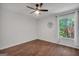 Spacious bedroom featuring hardwood floors, a window, and a modern ceiling fan at 100 Castlebrook Chase, Tyrone, GA 30290