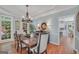 Open dining room area with large windows, hardwood floors, and view to the kitchen at 100 Castlebrook Chase, Tyrone, GA 30290