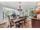 Bright dining room featuring hardwood floors, large windows, chandelier, and elegant dining table at 100 Castlebrook Chase, Tyrone, GA 30290