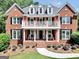 Stunning two-story brick home features a balcony, black shutters and lush landscaping at 100 Castlebrook Chase, Tyrone, GA 30290