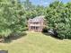 Aerial view of a traditional brick home with a well-manicured lawn, mature trees, and decorative balcony at 100 Castlebrook Chase, Tyrone, GA 30290