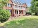 Charming two-story brick home with decorative balcony, white columns, and a lush front lawn at 100 Castlebrook Chase, Tyrone, GA 30290