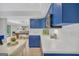 This kitchenette features blue cabinets, stainless appliances, white subway tile, and a cozy dining area at 100 Castlebrook Chase, Tyrone, GA 30290
