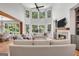 An open-concept living room showcases expansive windows, a fireplace, and comfortable seating at 100 Castlebrook Chase, Tyrone, GA 30290
