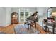 Elegant living room with grand piano, decorative rug and bright, natural light from the large window at 100 Castlebrook Chase, Tyrone, GA 30290