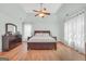 Bright main bedroom featuring a ceiling fan, tray ceiling, and rich hardwood floors at 100 Castlebrook Chase, Tyrone, GA 30290