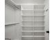 Clean, white walk-in closet with custom shelving and modern design at 100 Castlebrook Chase, Tyrone, GA 30290