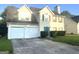 Two-story home with a two-car garage, lawn, and tidy landscaping at 2561 Lancewood Ln, Lithonia, GA 30035