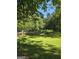 Lush backyard with green lawn and mature trees offering shade and privacy, ideal for outdoor enjoyment at 140 Dixie Ln, Covington, GA 30014