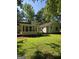 Home's back exterior features a screened-in porch, siding, and ample green space, blending indoor comfort with outdoor beauty at 140 Dixie Ln, Covington, GA 30014