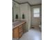 Bathroom with wallpaper, single vanity, toilet, and window at 140 Dixie Ln, Covington, GA 30014