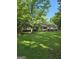 A well-manicured lawn and mature trees adorn this single-story home with red shutters and a quaint front porch at 140 Dixie Ln, Covington, GA 30014