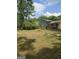 A spacious backyard with a lawn, mature trees, and a view of the home's exterior at 993 Roosevelt Se Dr, Atlanta, GA 30354