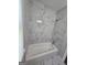 Bathroom featuring bright, white shower and tub with gray tiling and bright light from the window at 993 Roosevelt Se Dr, Atlanta, GA 30354
