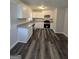 Modern kitchen features white cabinets, granite countertops, stainless steel appliances, and stylish dark wood-look flooring at 993 Roosevelt Se Dr, Atlanta, GA 30354
