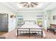Bedroom with green walls, neutral carpet, a black metal bed frame, and natural light from two windows at 357 Old Driver Rd, Whitesburg, GA 30185