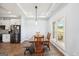 Bright dining room with modern lighting, wood floors, and a view of the landscaped yard at 357 Old Driver Rd, Whitesburg, GA 30185