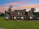 Beautiful single-Gathering home with a light brick exterior and a spacious, covered front porch at sunset at 357 Old Driver Rd, Whitesburg, GA 30185