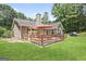 Charming backyard featuring a spacious wooden deck, lush green lawn, and mature trees at 8340 Highway 54, Sharpsburg, GA 30277