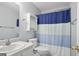 Bathroom featuring a vanity, toilet, and a blue and white striped shower curtain creating a clean, functional space at 8340 Highway 54, Sharpsburg, GA 30277