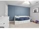 Charming bedroom with a decorative blue accent wall, plush carpet, and a cozy daybed with built-in drawers at 8340 Highway 54, Sharpsburg, GA 30277