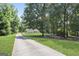 Long driveway leading to a cozy home surrounded by mature trees, offering privacy and a sense of tranquility at 8340 Highway 54, Sharpsburg, GA 30277