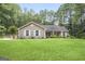 Charming single-story home with a well-manicured lawn and surrounded by lush greenery and mature trees at 8340 Highway 54, Sharpsburg, GA 30277